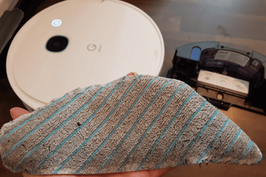 В руках грязная салфетка от робота-пылесоса